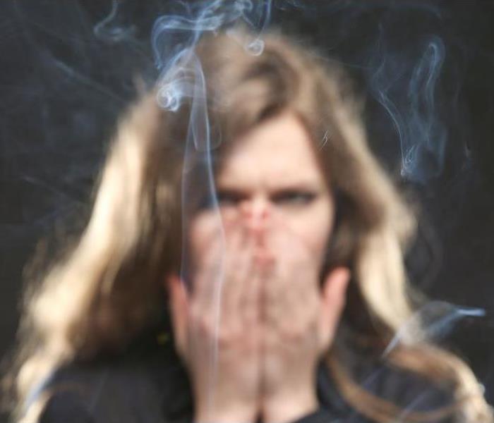 woman behind smoke covering nose