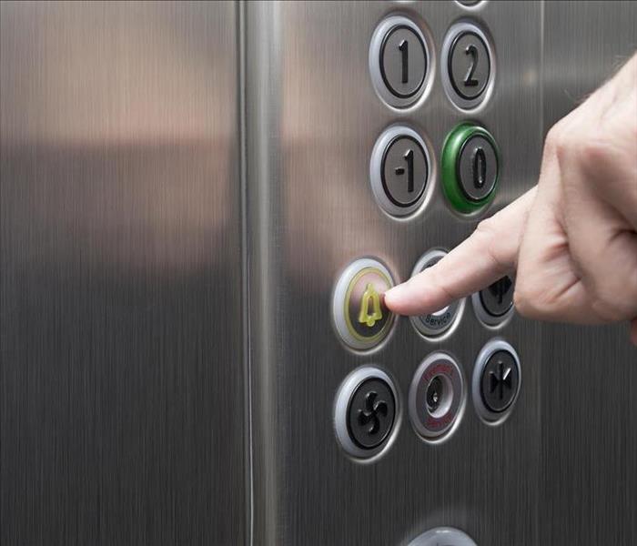 employee hand pressing an elevator button