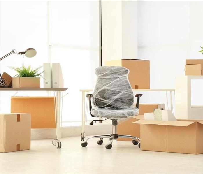 boxed office supplies and plastic wrapped office chairs